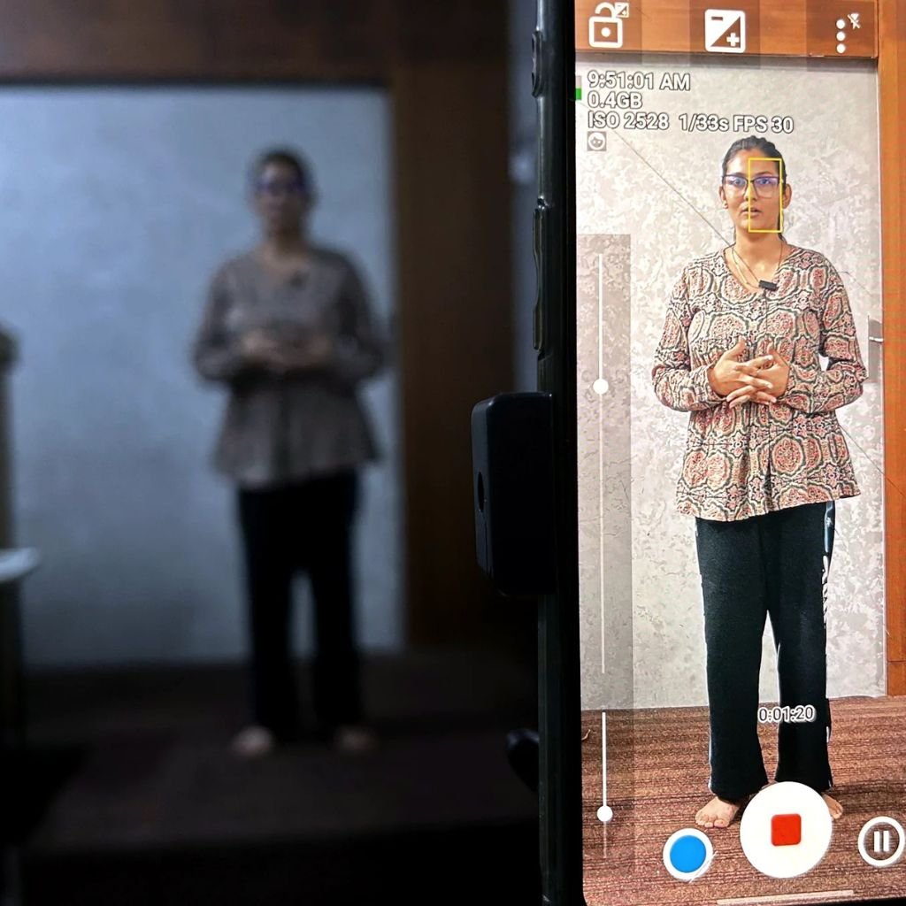 Student reviewing a recorded speaking performance on a smartphone during interview preparation at AIM English Raipur