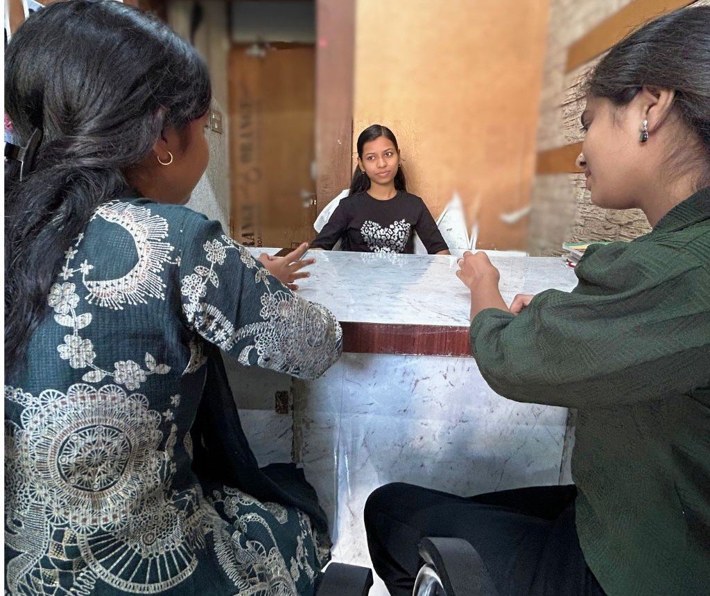 Teacher conducting a mock interview with two students at AIM English Raipur