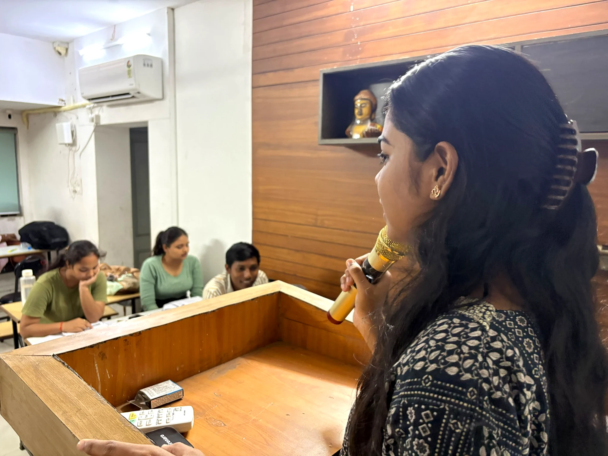 Student practising spoken English with a microphone at AIM English Raipur