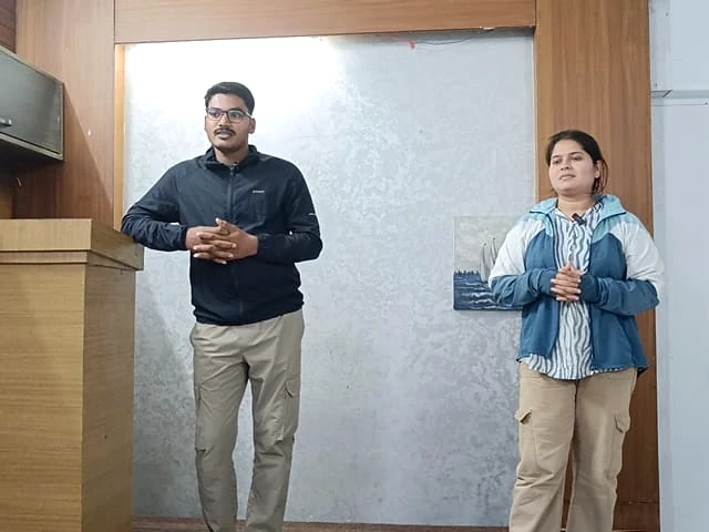 Two students practising public speaking on stage at AIM English Raipur