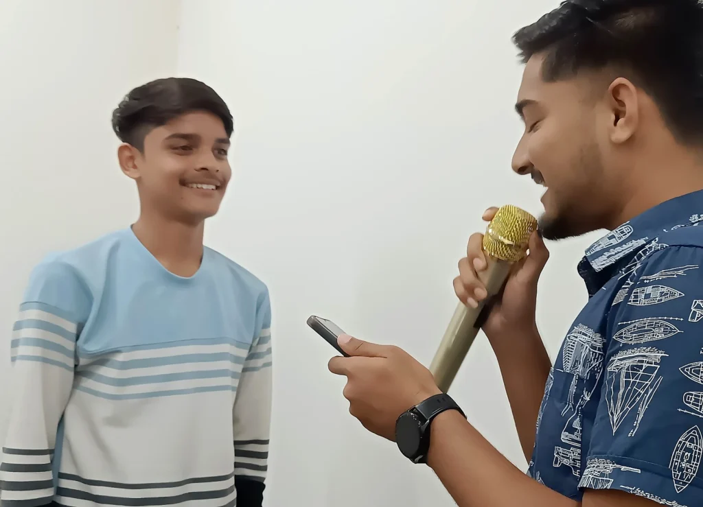 Students practising spoken English with a microphone during a conversation activity at AIM English Raipur